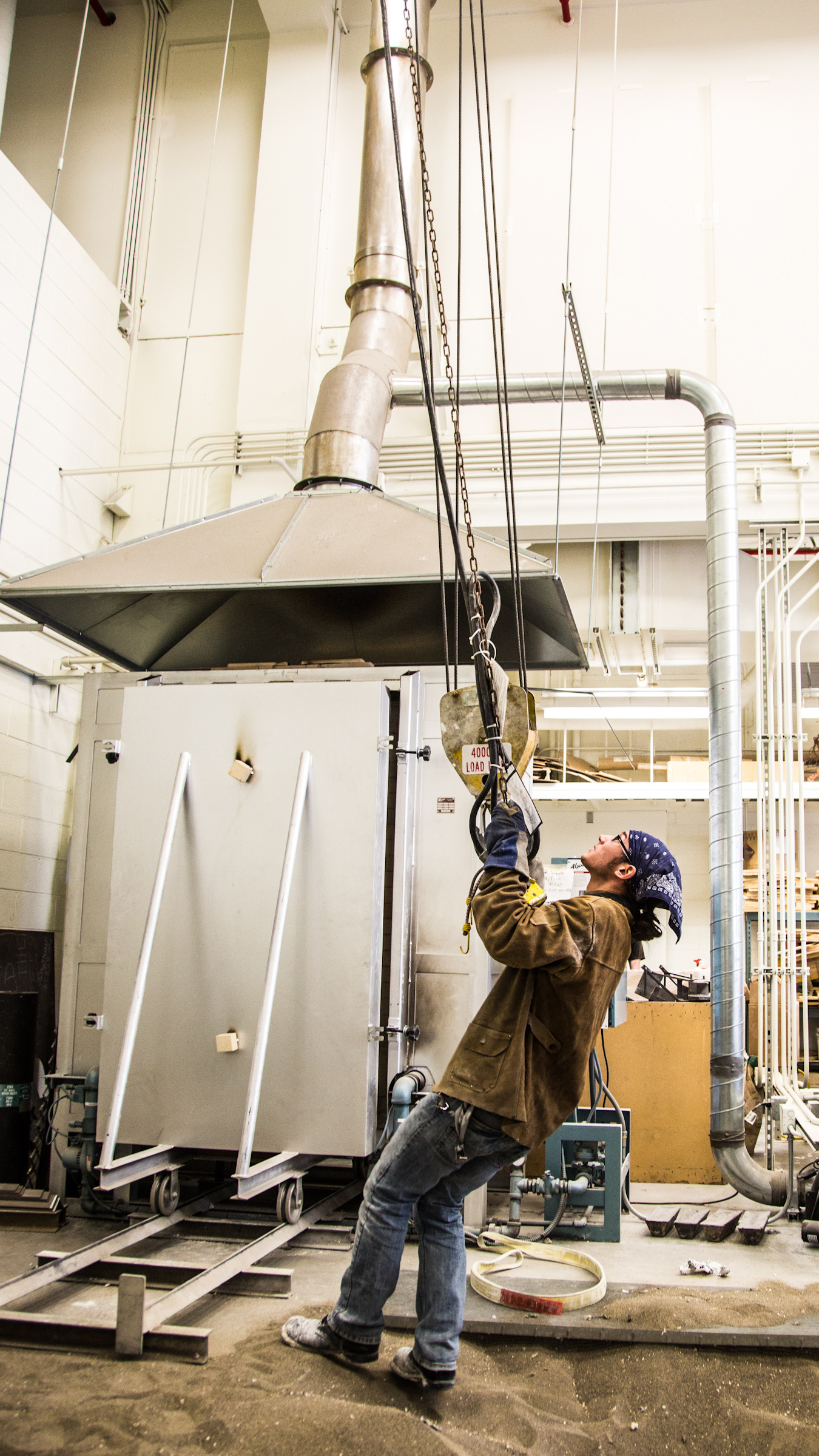 Art major Joel Isaak positions equipment prior to pouring molten bronze as part of the process of creating a life-sized sculpture for his senior thesis in the UAF Fine Arts complex. | UAF Photo by Todd Paris