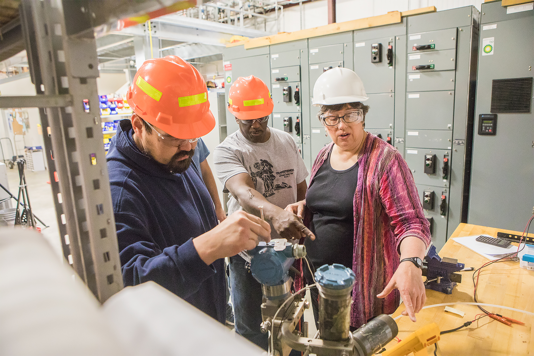 Students Glen Morgan, left, and Ernest Holt, center, listen as Teresa Lantz, assistant professor of process technology, demonstrates how to use a bubbler to monitor water levels in a tank in July 2017. Morgan and Holt were participating in the UAF Community and Technical College’s mining mill operator training program at a facility leased from the Fairbanks Pipeline Training Center off Van Horn Road. UAF photo by JR Ancheta
