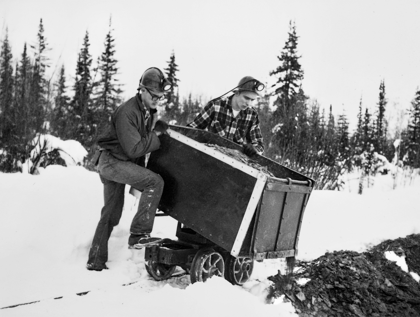 Students dump a rail-mounted cart after mucking out the results of a winter blast in the adit. Earl Beistline Collection, Accession number 1985-093-623, Archives, Alaska and Polar Regions Collections, Rasmuson Library, University of Alaska Fairbanks