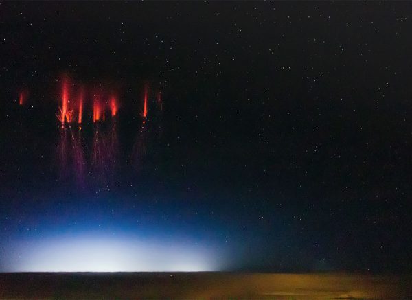 UAF graduate student Jason Ahrns photographed these sprites, or red lightning, with his personal D7000 Nikon camera in 2013 using a $120 35mm f/1.8 lens. He captured the color images while helping photograph sprites from a National Center for Atmospheric Research aircraft that carried $100,000 worth of equipment able to shoot black and white images at 10,000 frames per second.