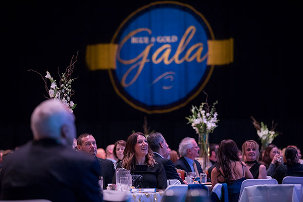 Smiling attendees seated at tables at the UAF Blue and Gold Celebration