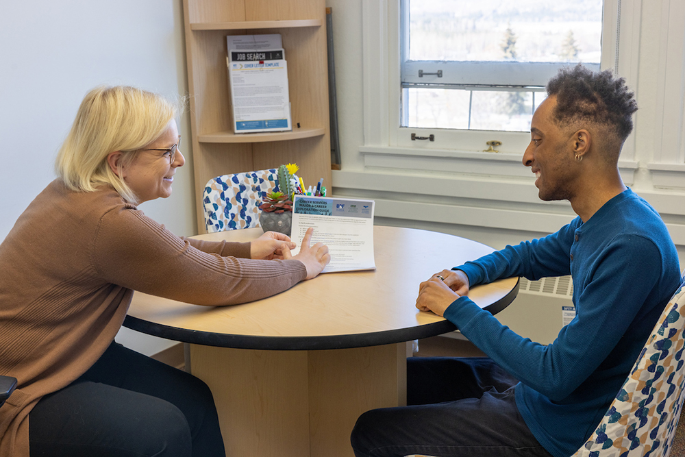 Nicole Goff works with River Schumann during this staged advising photo shoot at Career Services in the Eielson Building on the UAF campus Monday, May 1, 2023. | UAF Photo by Eric Engman