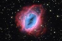 A blue and pink nebula in a starry sky.