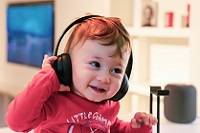 Child wearing headphones and smiling.