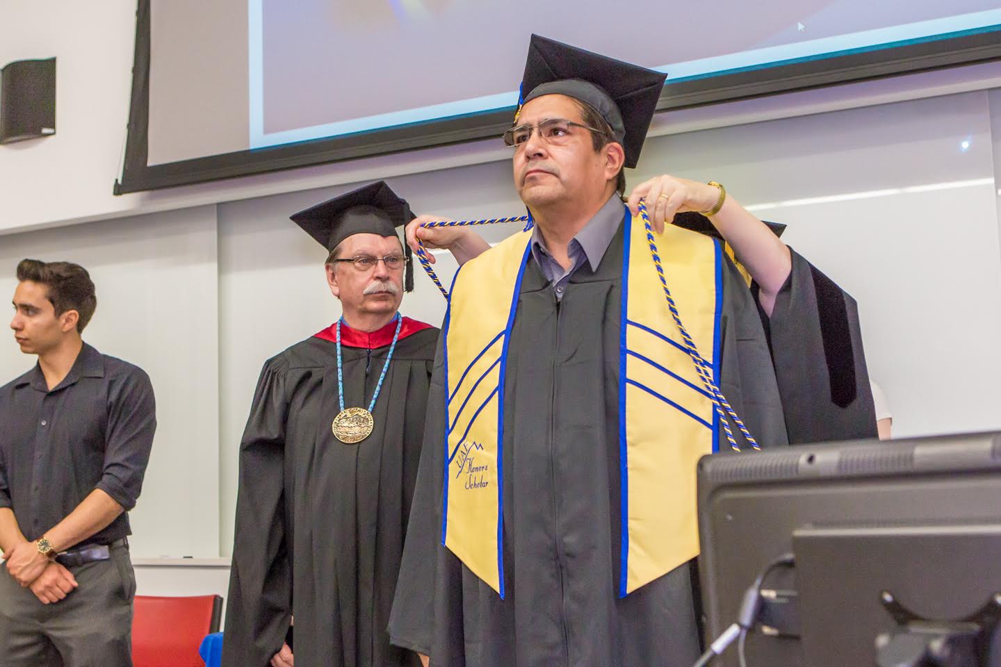 Jeff Thompson receives his cords and sash during the UAF Honors Program commencement ceremony May 9, 2015