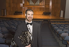 John poses with his horn in the Davis Concert Hall
