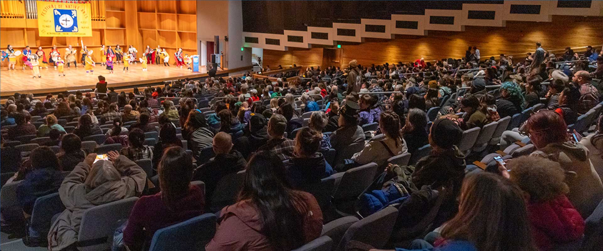 Audience members at the Charles Davis Concert Hall at the Troth Yeddha' Campus in Fairbanks watch a dance performance during the Festival of Native Arts