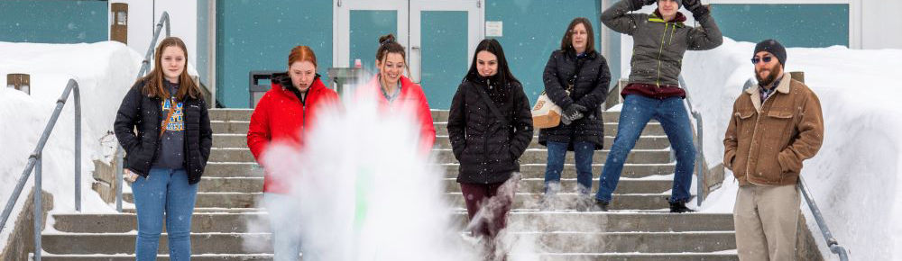 Image of students watching an outdoor demonstration of exploding chemicals.