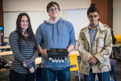 Three students hold their invention