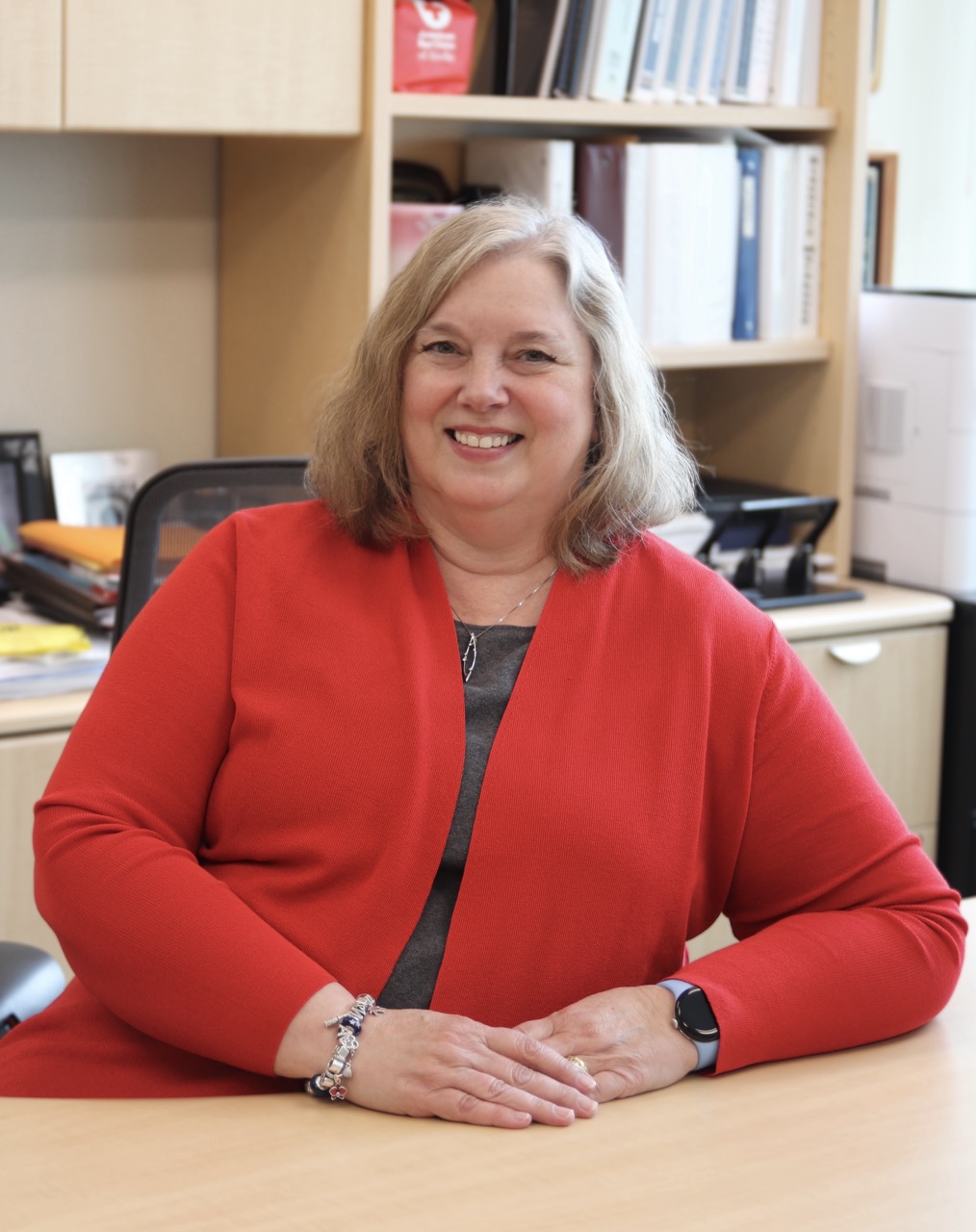 Patty Mongold poses at desk for portrait