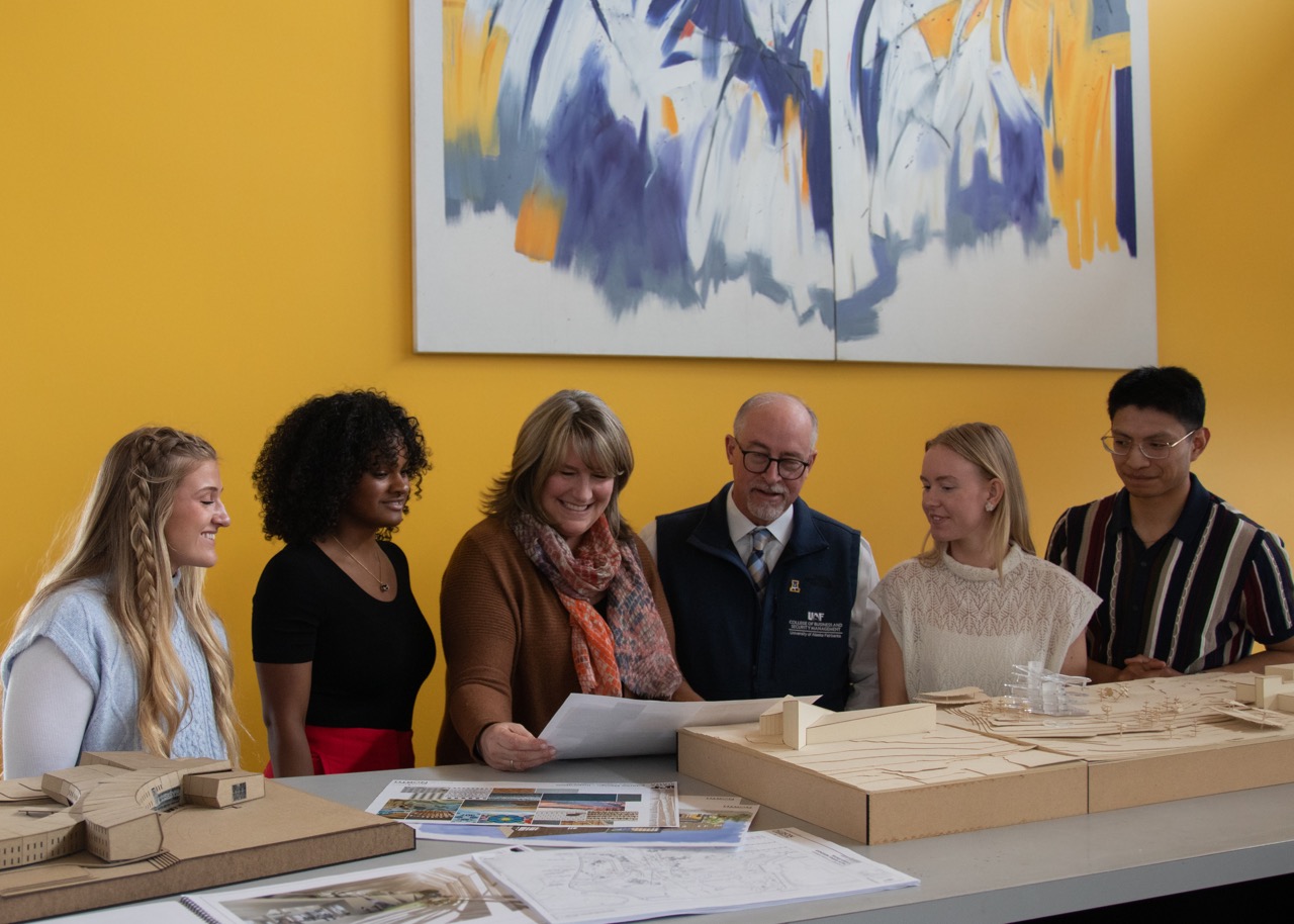 Tracy Vanairsdale shows blueprints to CBSM students and dean.