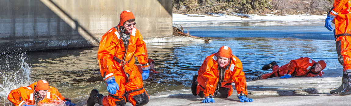UAF students climb out of the frigid Chena River onto its icy banks during cold water rescue training