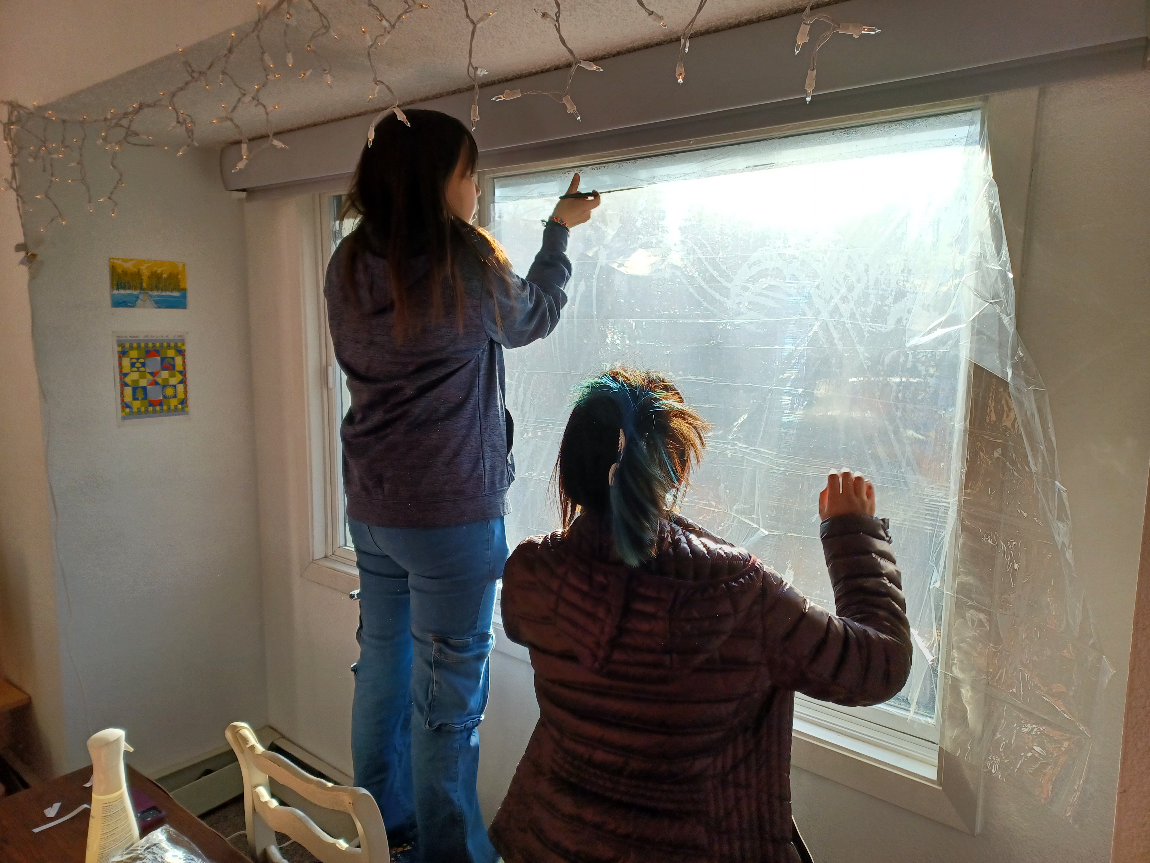 Students work together to retrofit a condo with window film. Photo by George Reising/ACEP.