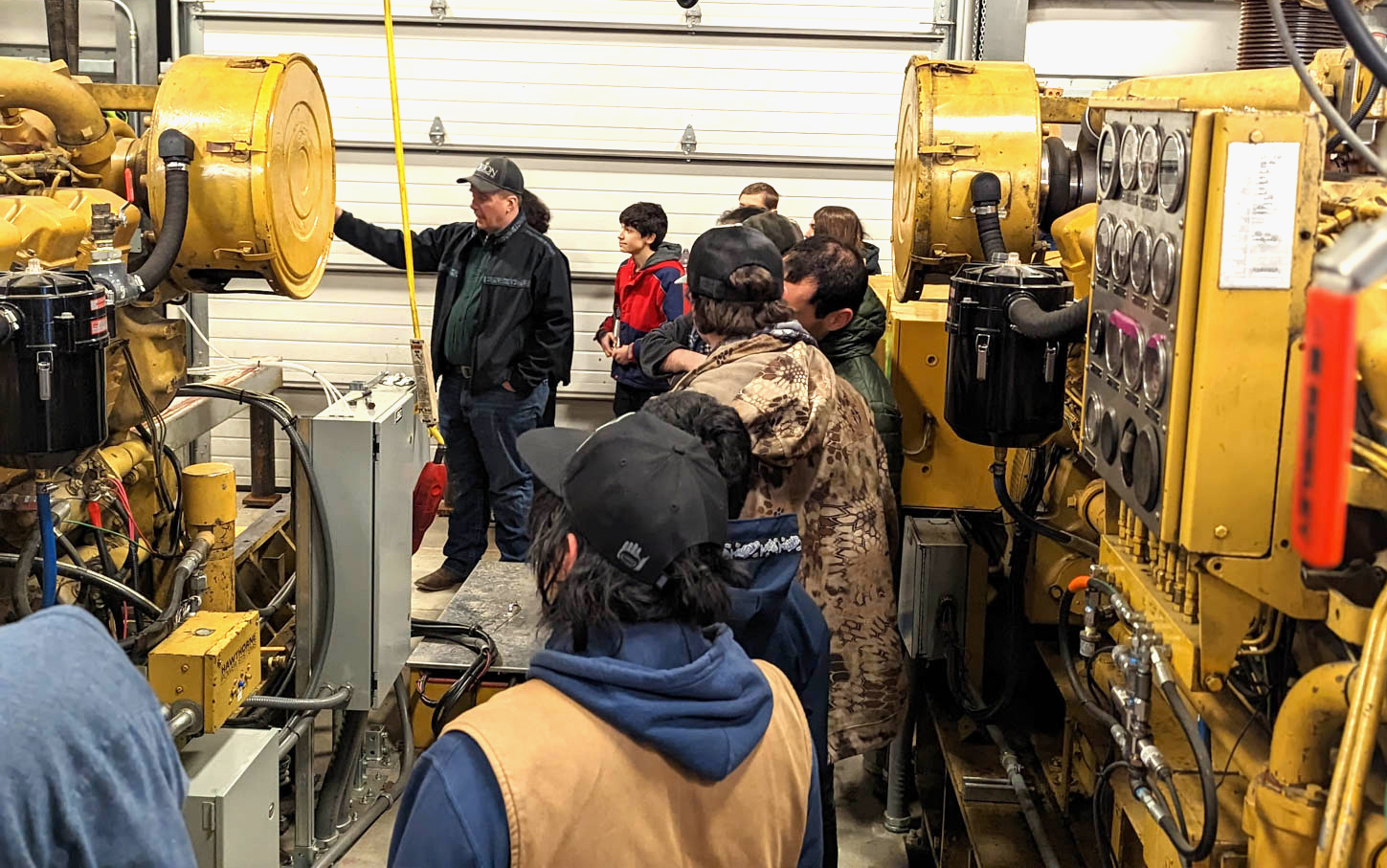 A person is giving a tour of a power plant to a group of people.