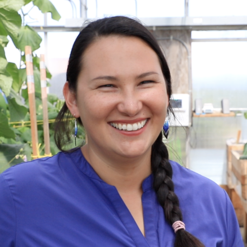Head shot of AlexAnna Salmon of Igiugig, Alaska smiling in a greenhouse.
