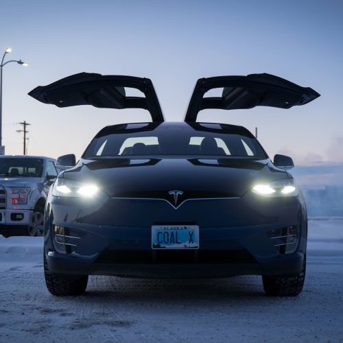 Tesla with doors open in the winter. License plate reads 