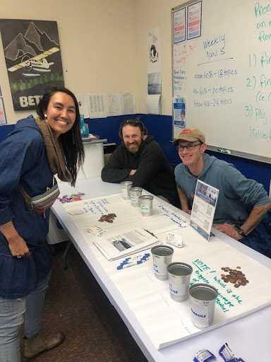 Chris Pike and Leif Albertson talk electric vehicles with Tina Harness at Cama-i in Bethel in March. Photo by Michelle Wilber.