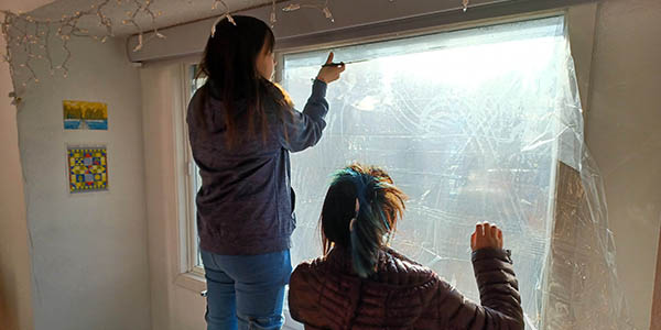 T3 students work together to retrofit a condo with window film.