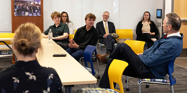 ACEP intern Liam Chelkowski speaks to Governor Dunleavy about his research on the carbon baseline data collection on the Railbelt. Photo by Amanda Byrd/ACEP.