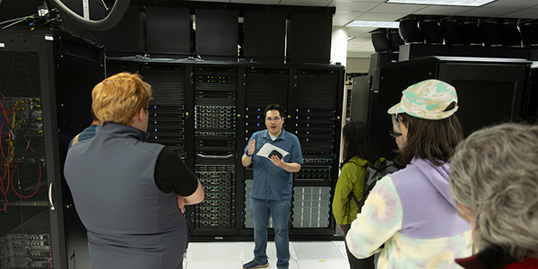 A person is talking to a group of people at a data center.