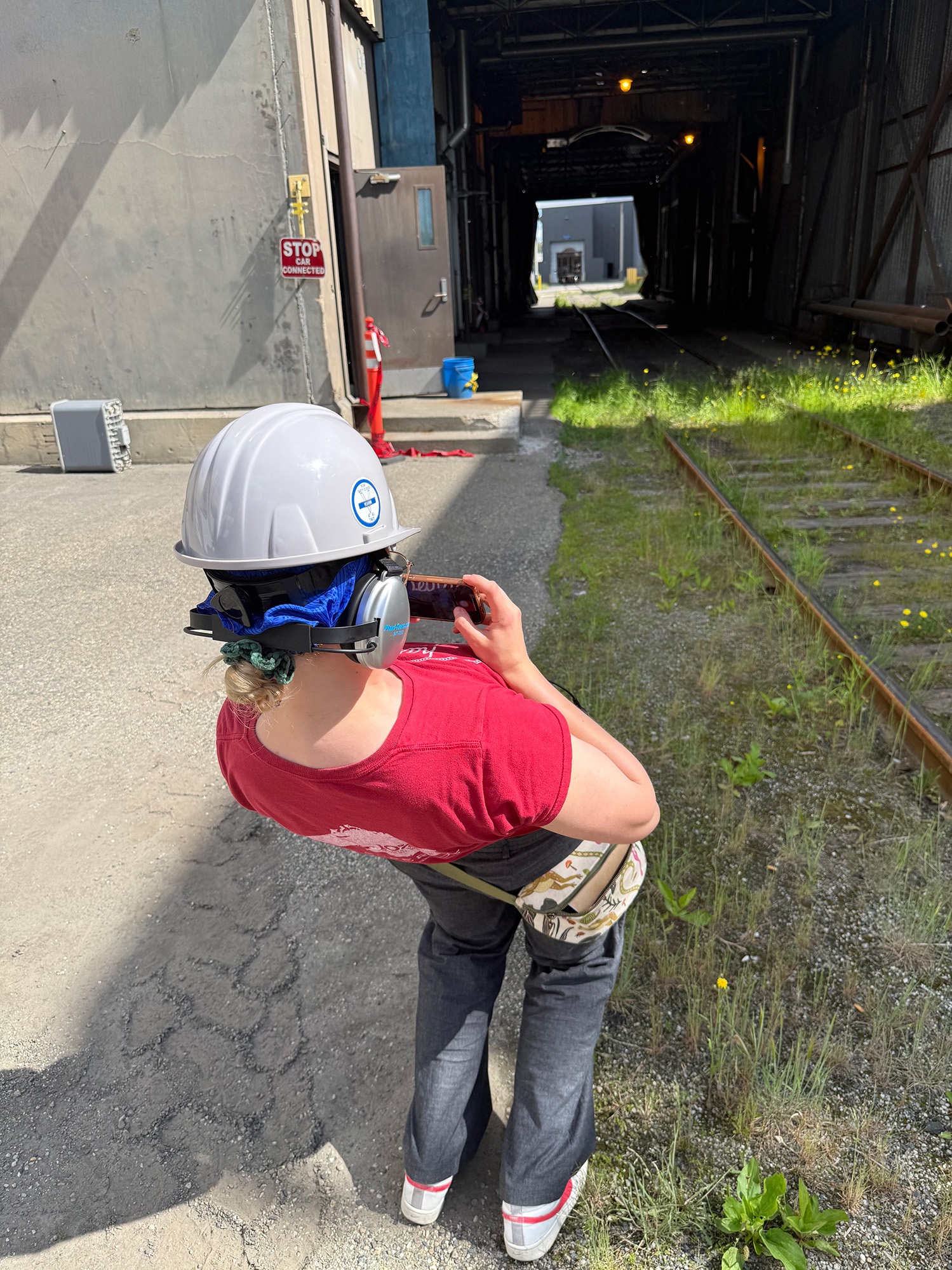 A person with a safety helmet is bending backwards trying to take a good shot of a tunnel