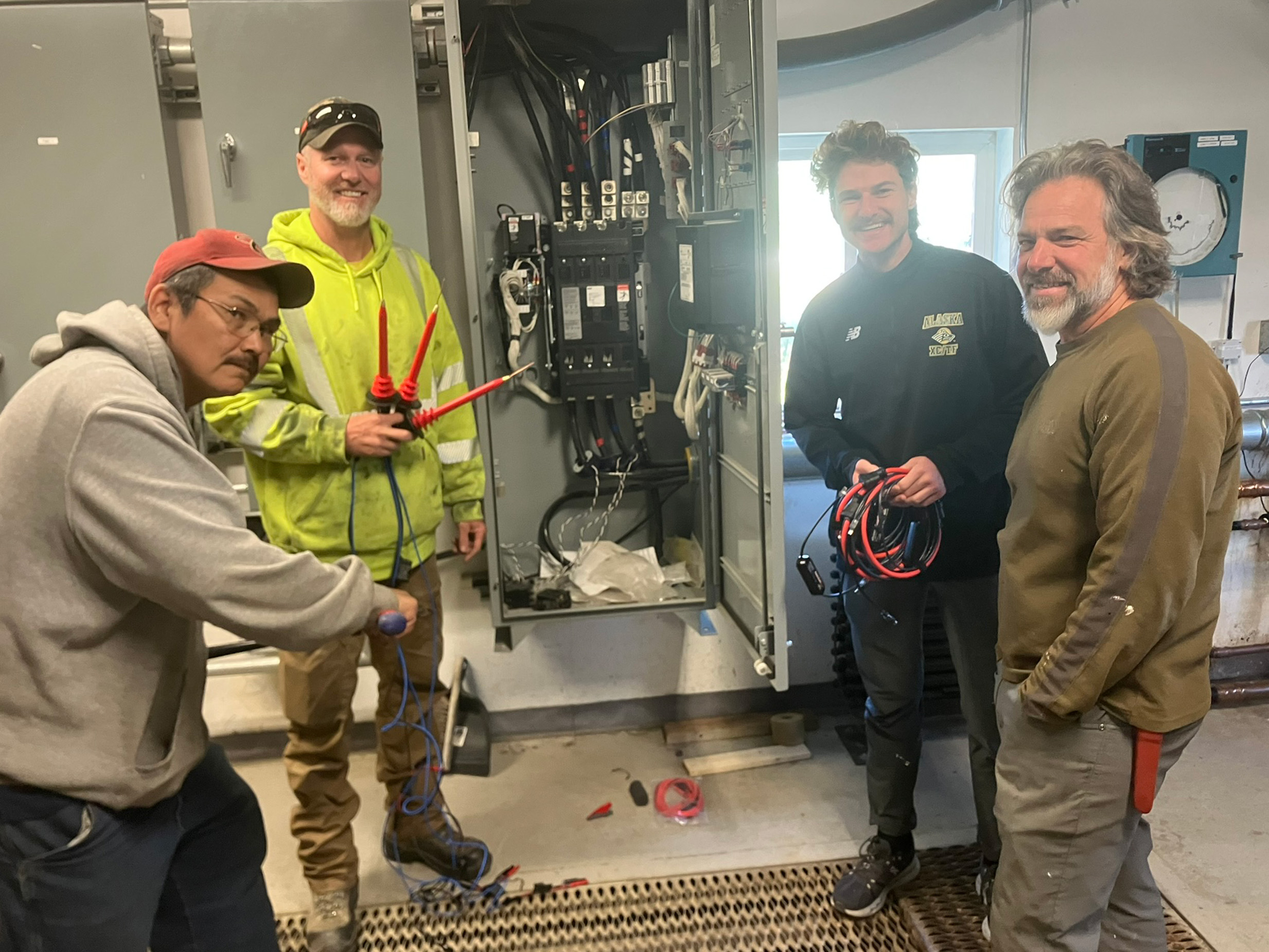 Four people in a utility room pose for a photo
