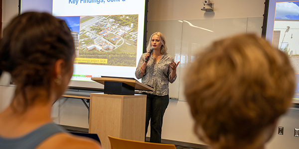 A person with a mic giving a presentation.