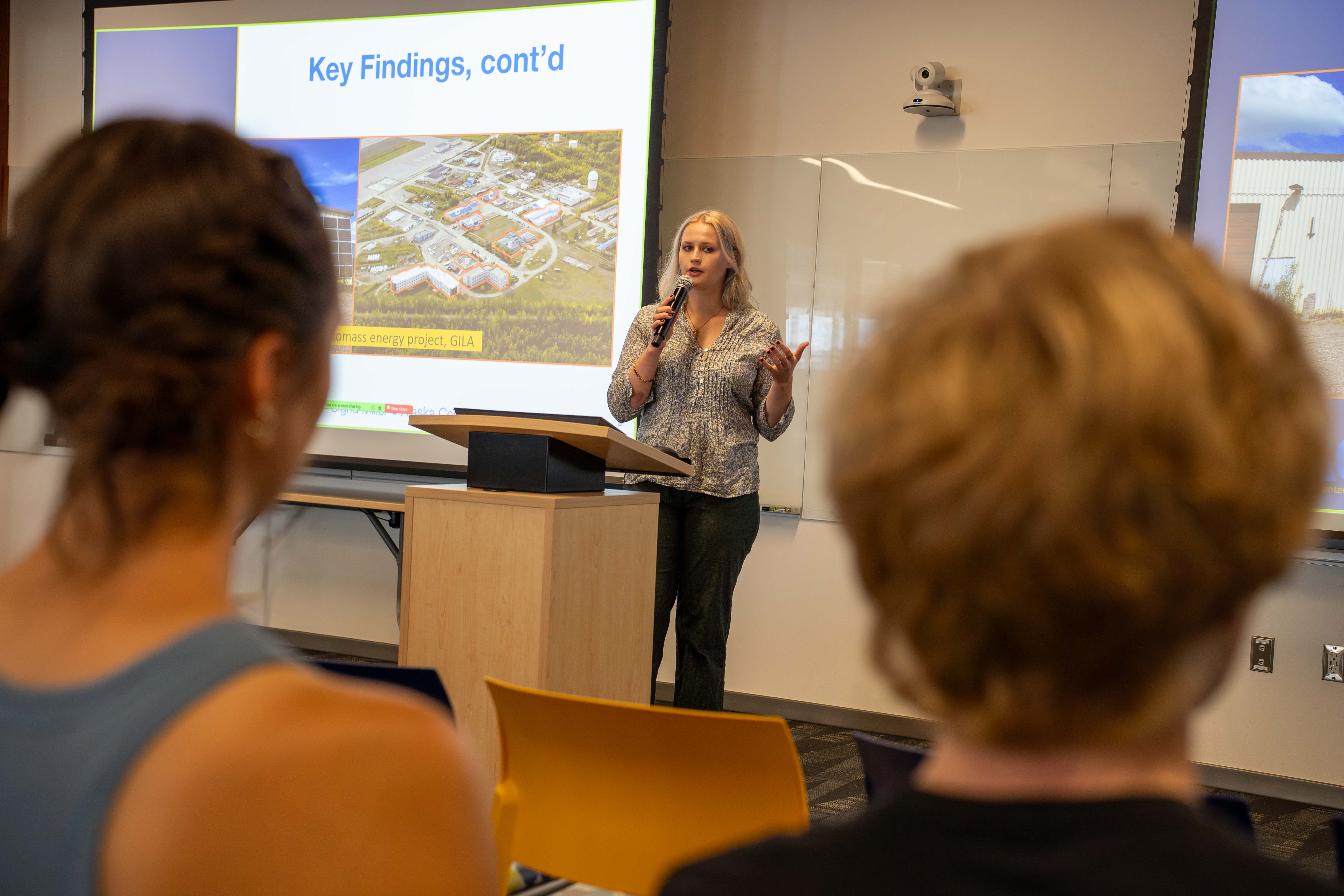 A person with a mic giving a presentation.