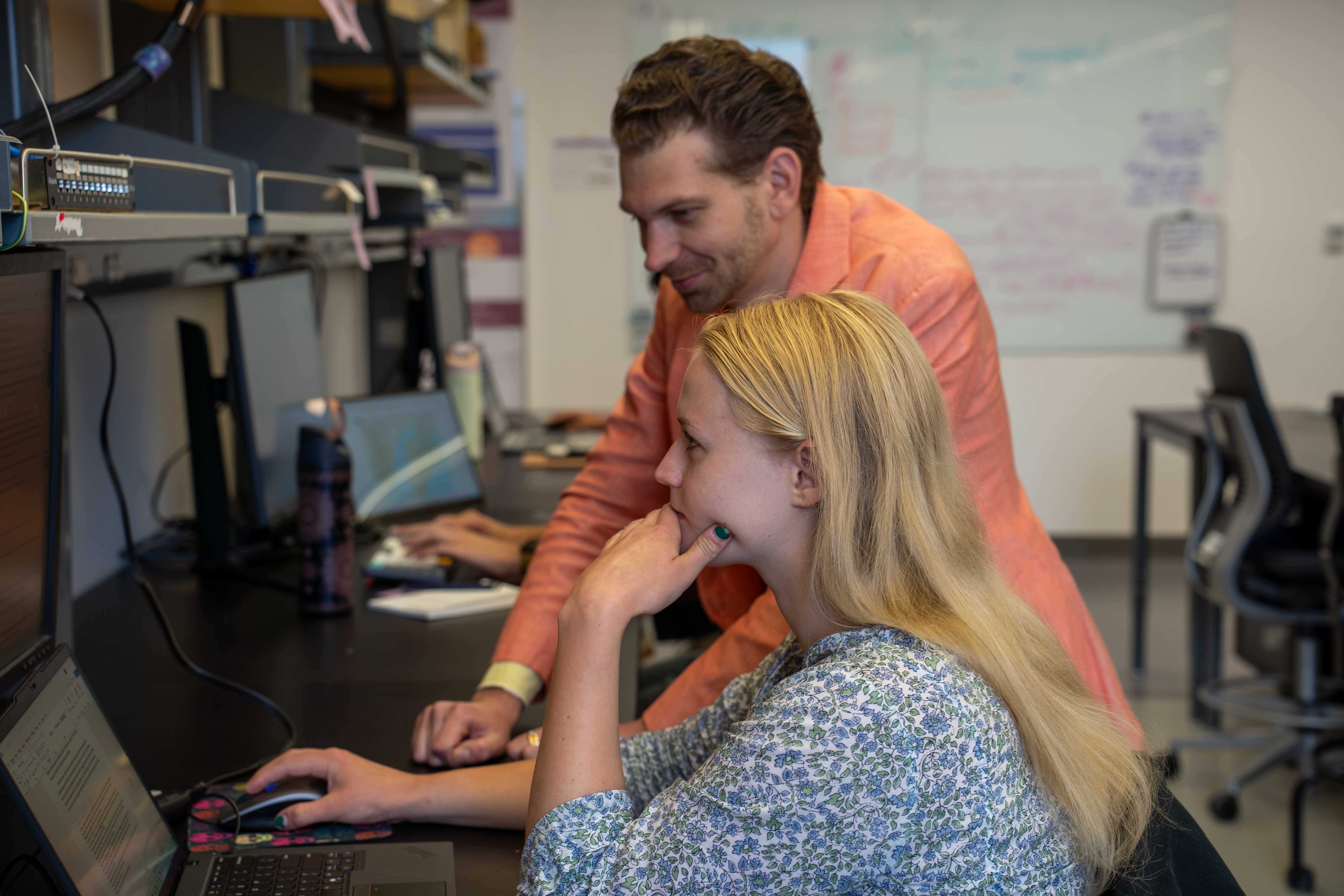 Two people looking at a computer screen during discussion
