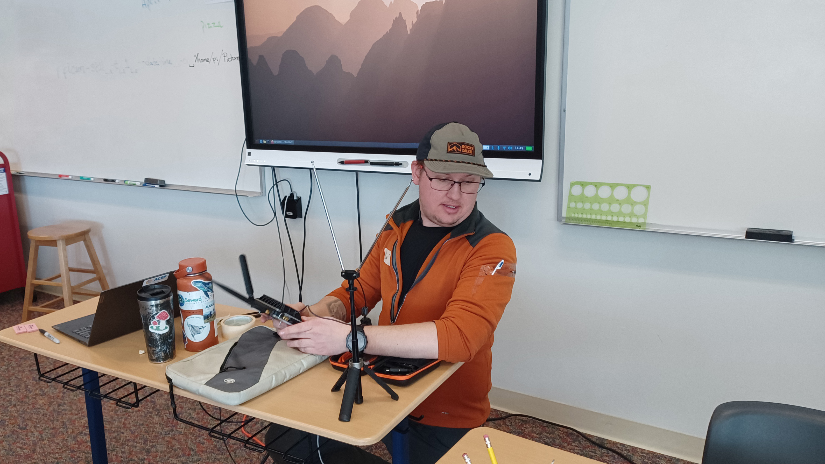 A person sitting at a desk is demonstrating how to listen to radio signals