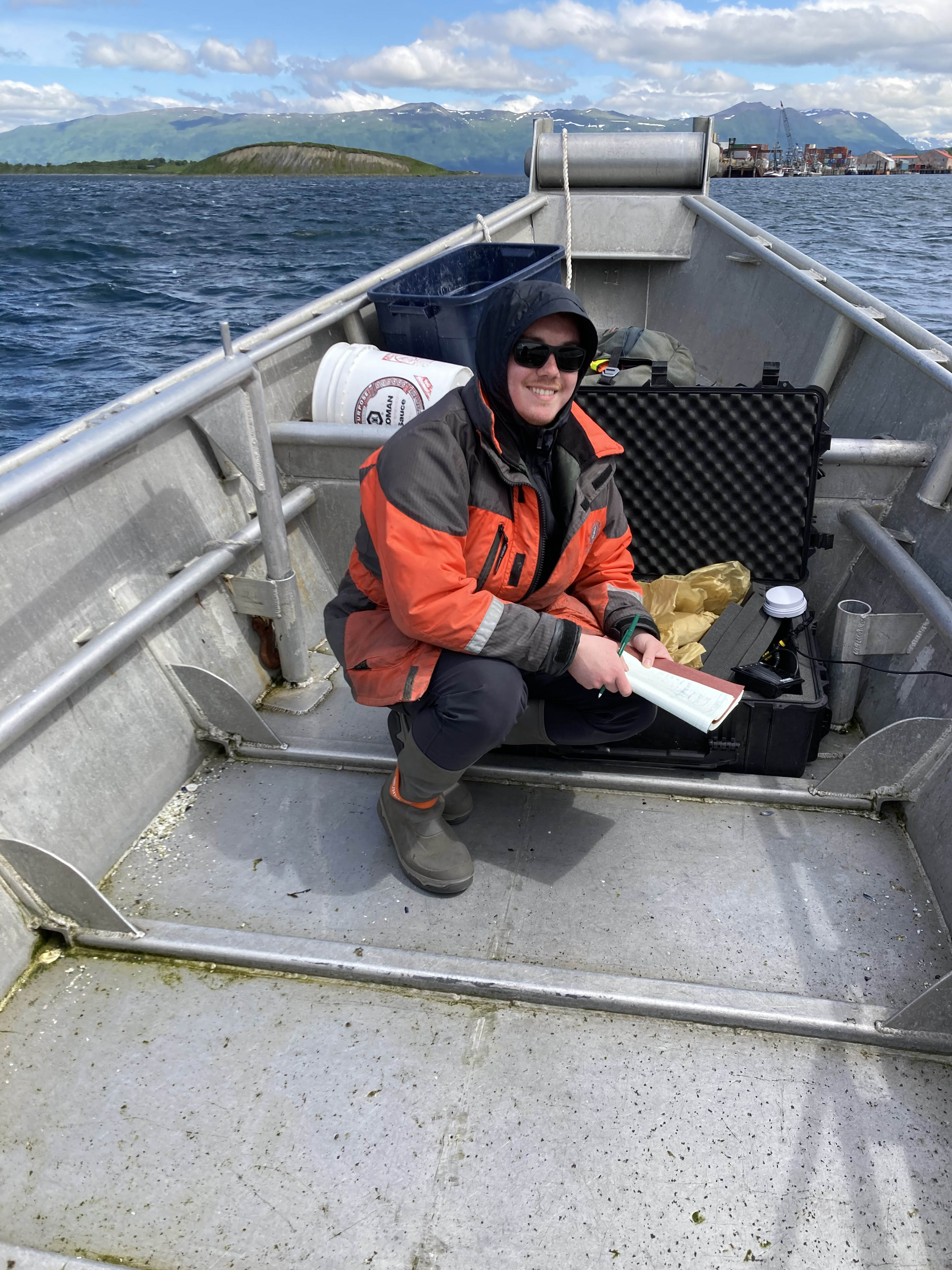 2023 summer intern Kristian Nudlash-Barger works in Larsen Bay with the data logging equipment he designed.