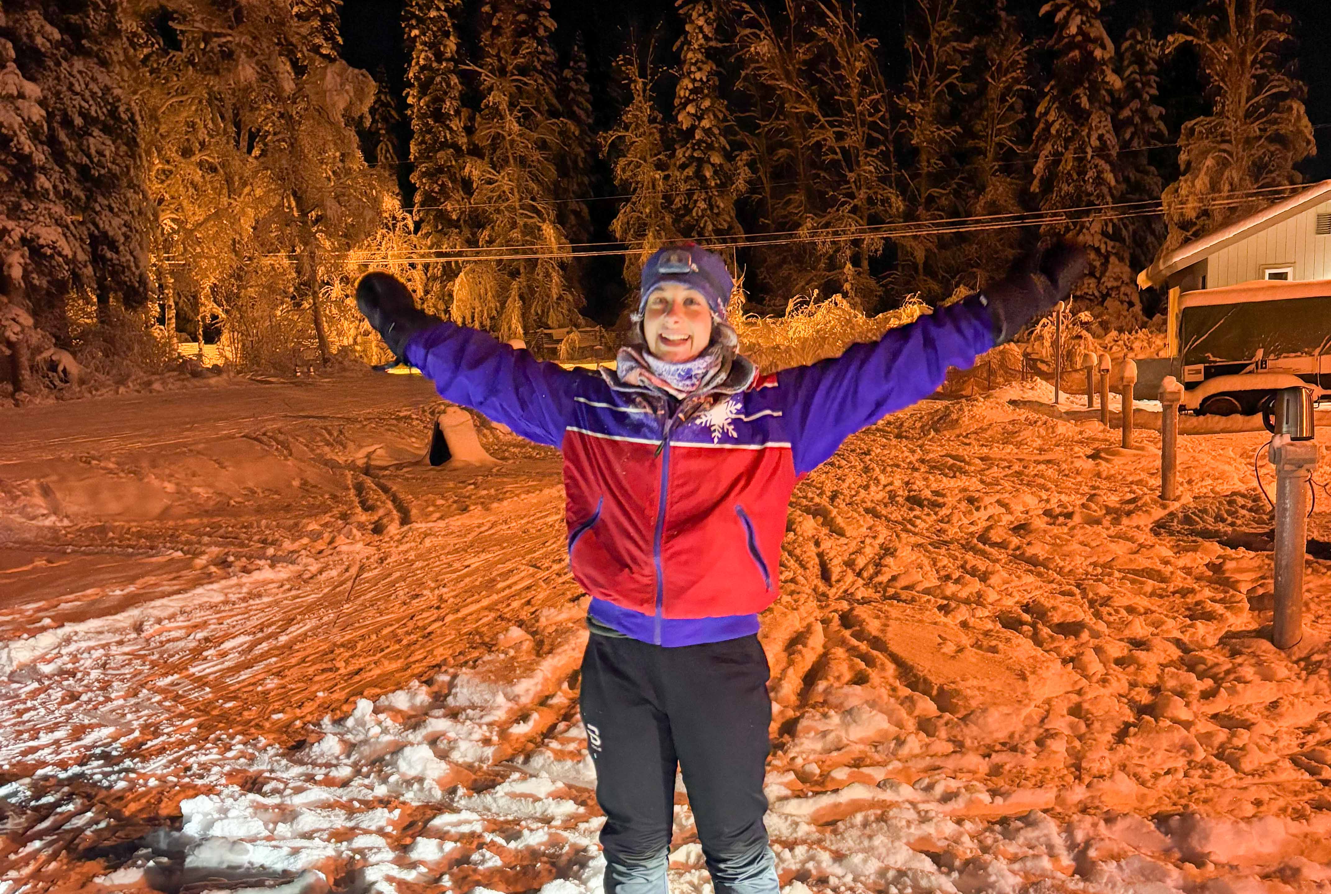 A person in ski gear spreading her arms