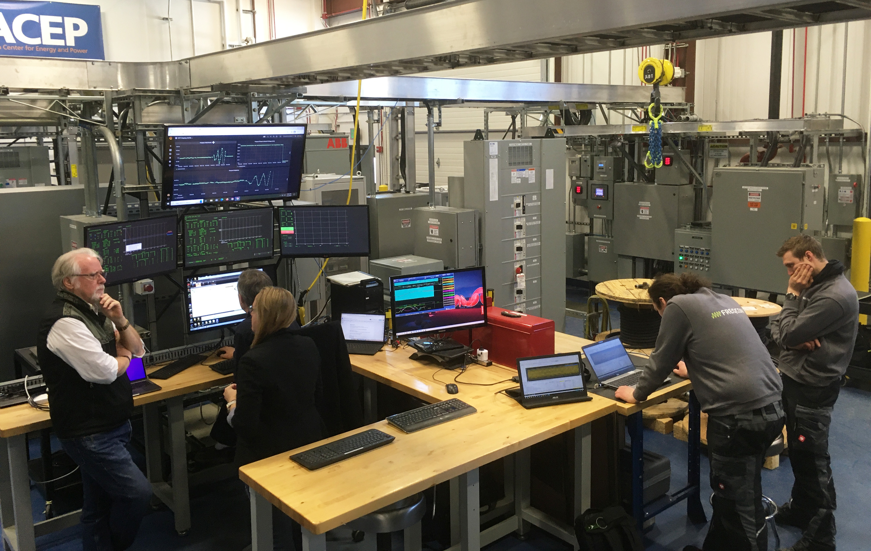 ACEP, AVEC and Freqcon staff troubleshoot the GBS modules in the ACEP Energy Technology Facility lab.