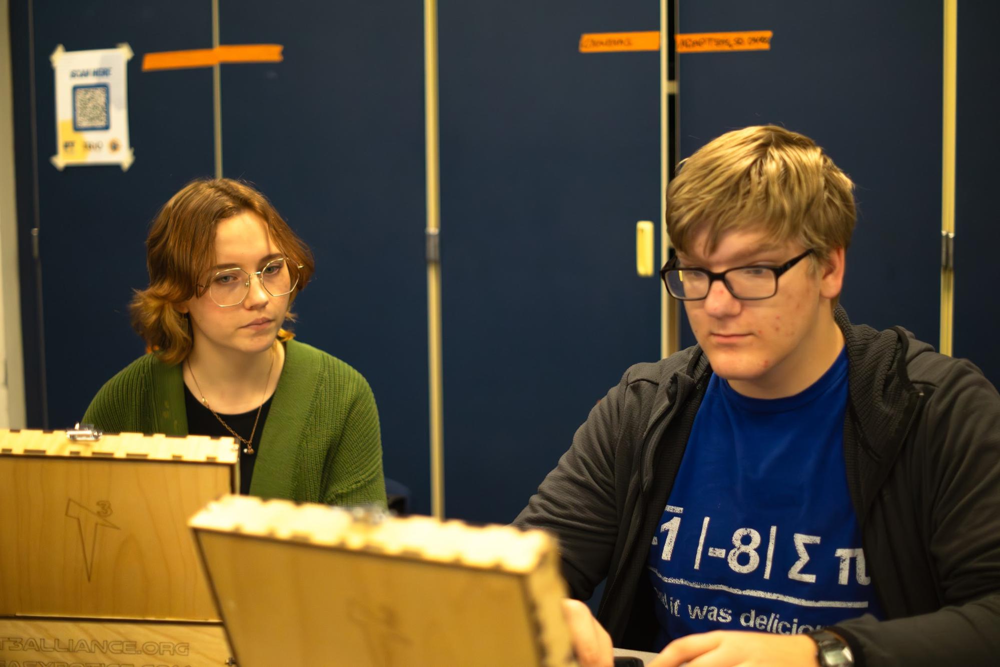 A person is helping the other person with a computer activity