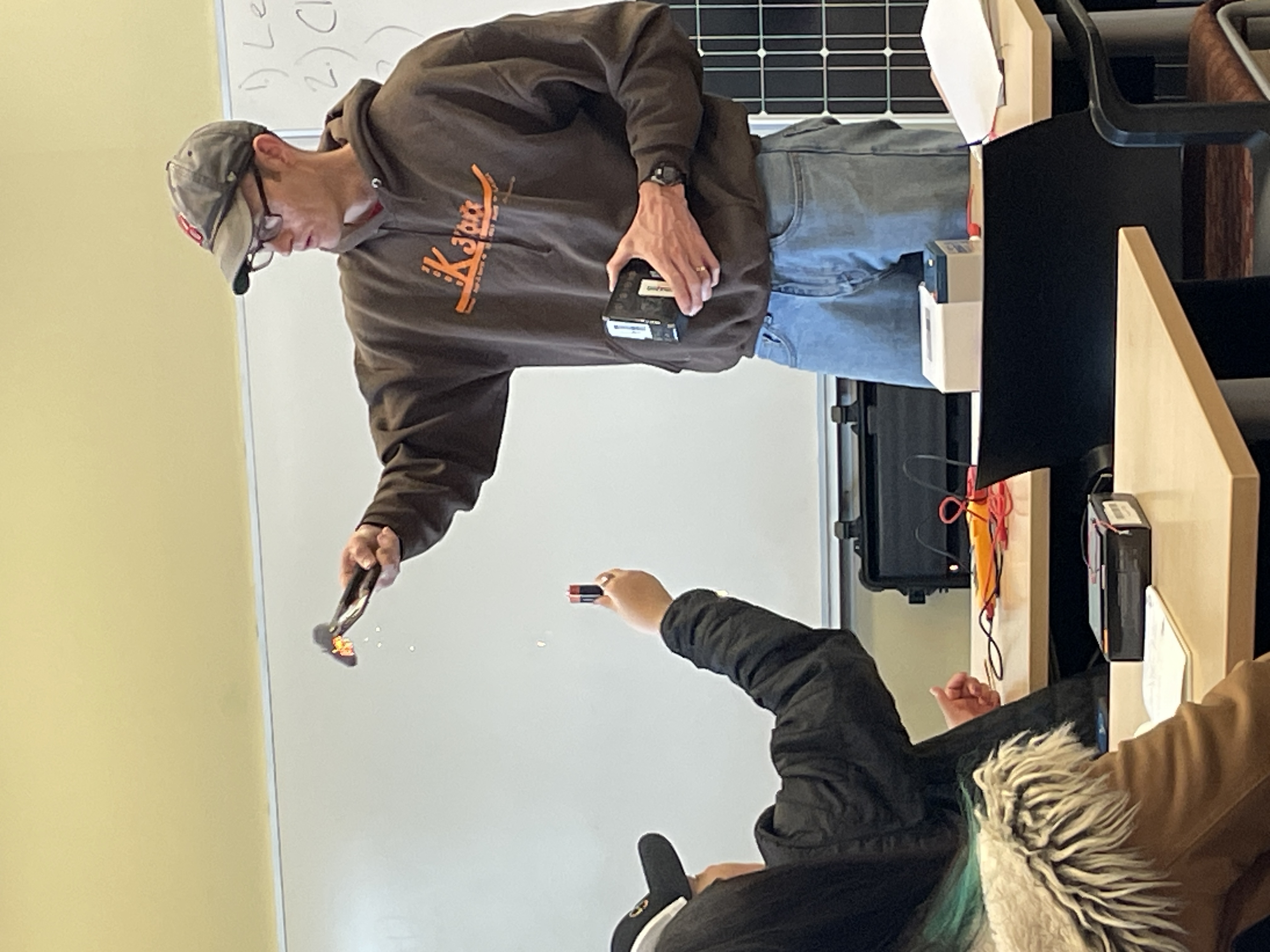 Chris Pike shows students what happens when one short-circuits a battery.