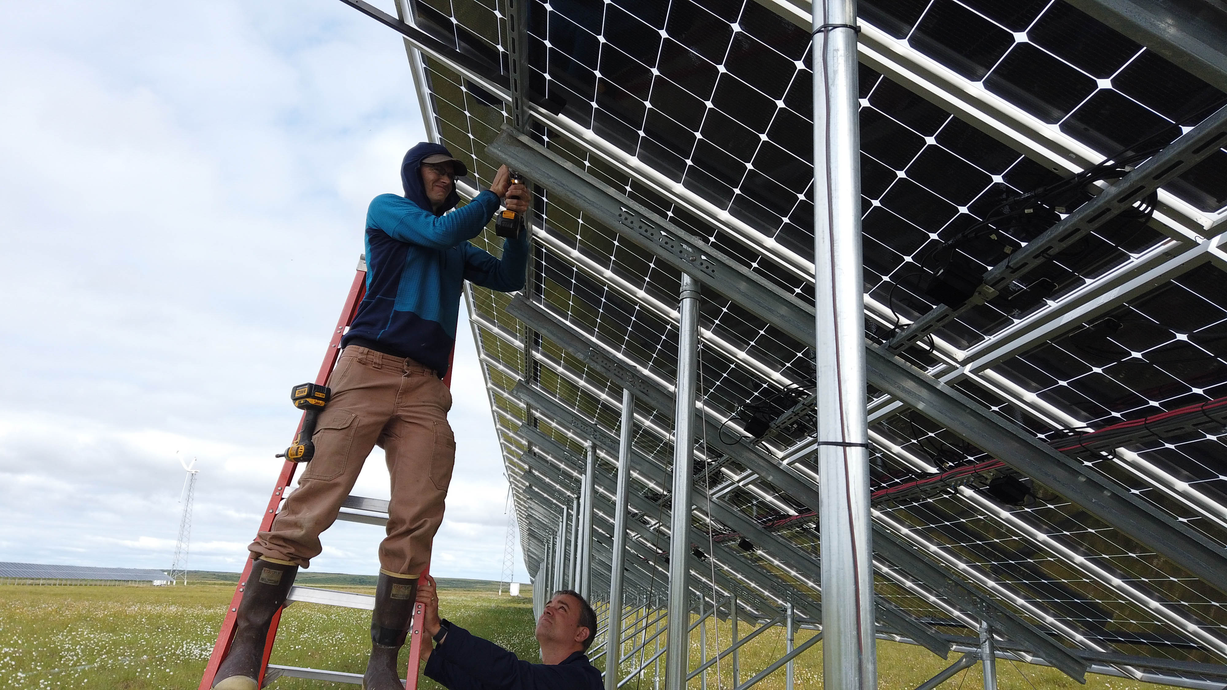 ACEP researcher installs monitoring equipment on the Kotzebue Electric Association solar farm.