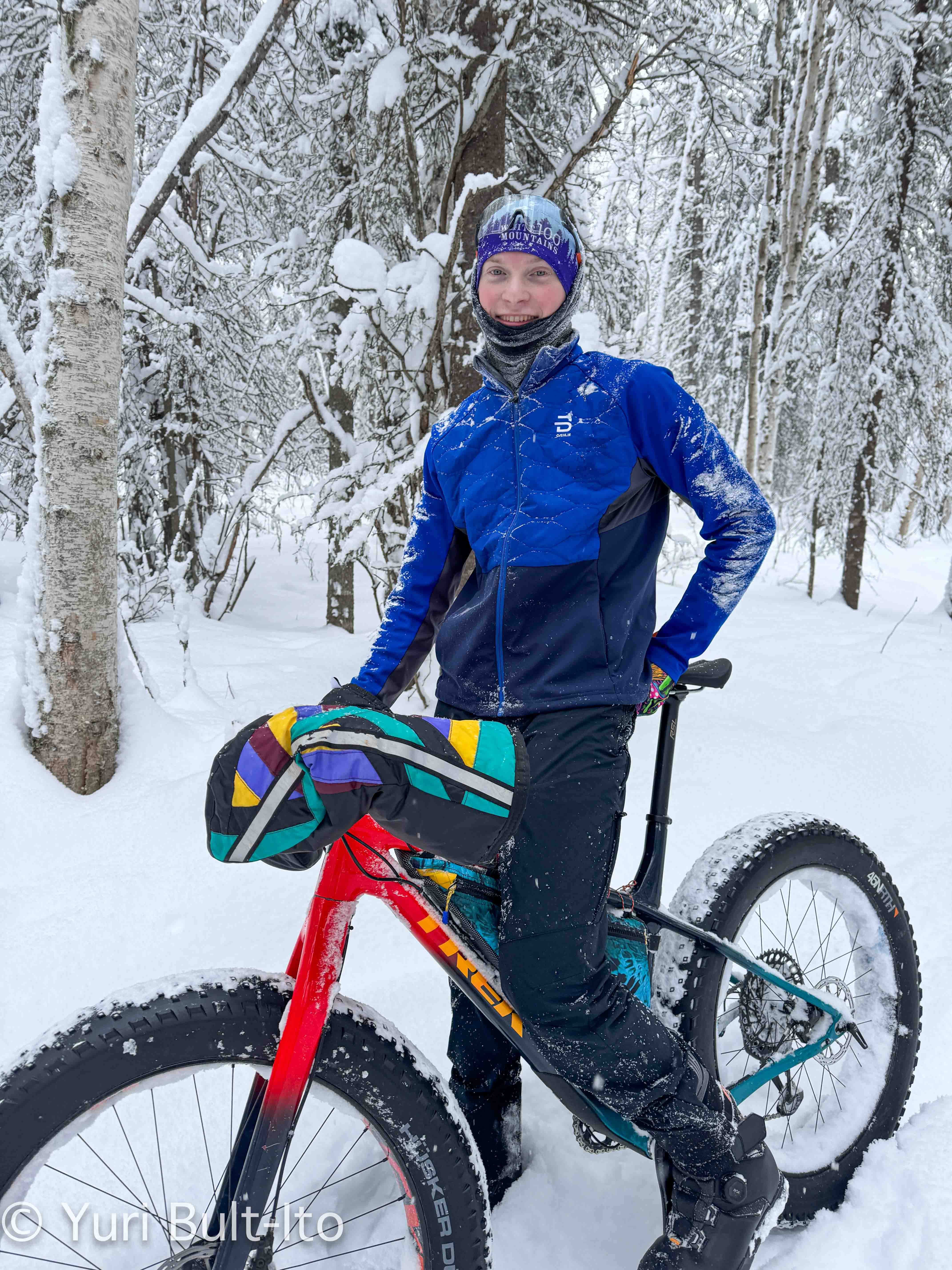 A person standing on a bike in the snow