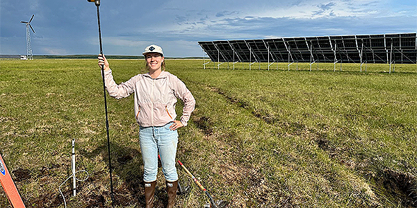 Kathryn Modler installs the ground temperature monitoring system she designed to gain knowledge about whether and how the shifting permafrost causes some of the panels to heave around the solar array in Kotzebue, Alaska. Photo by Chris Pike.