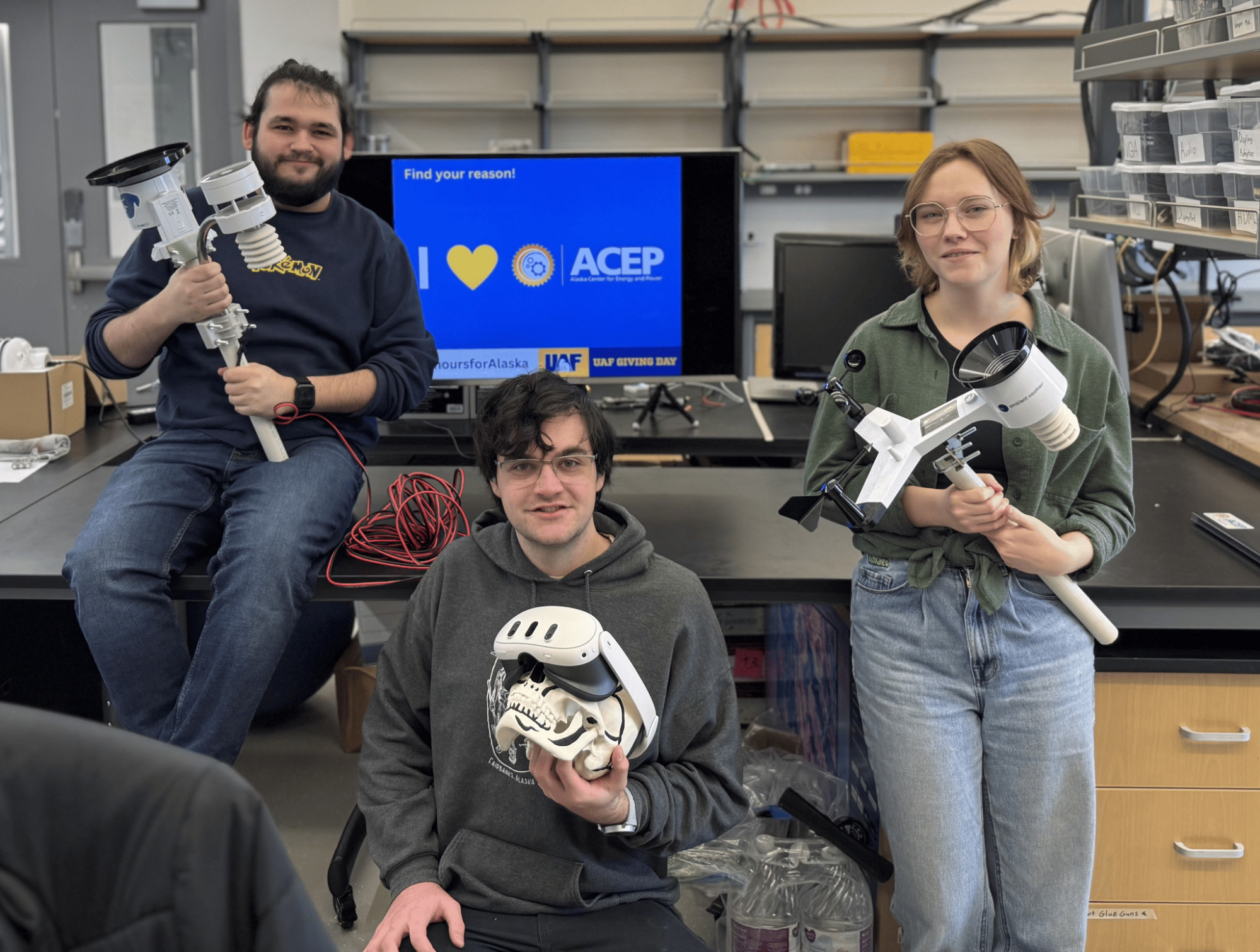 Three people holding science instruments pose for a photo