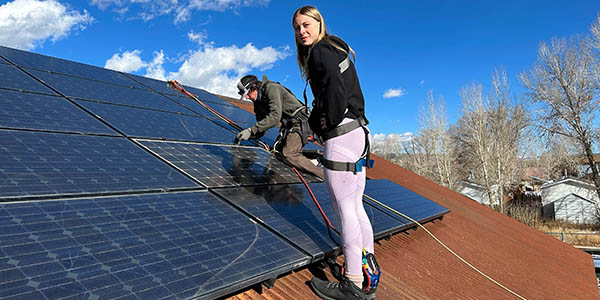 A student works with Nunatak Alternative Energy Solutions’s staff on a Habitat for Humanity house, using reused solar panels and rails.