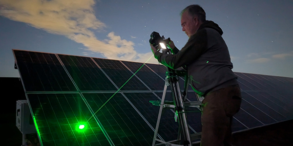 A person is inspecting a solar panel