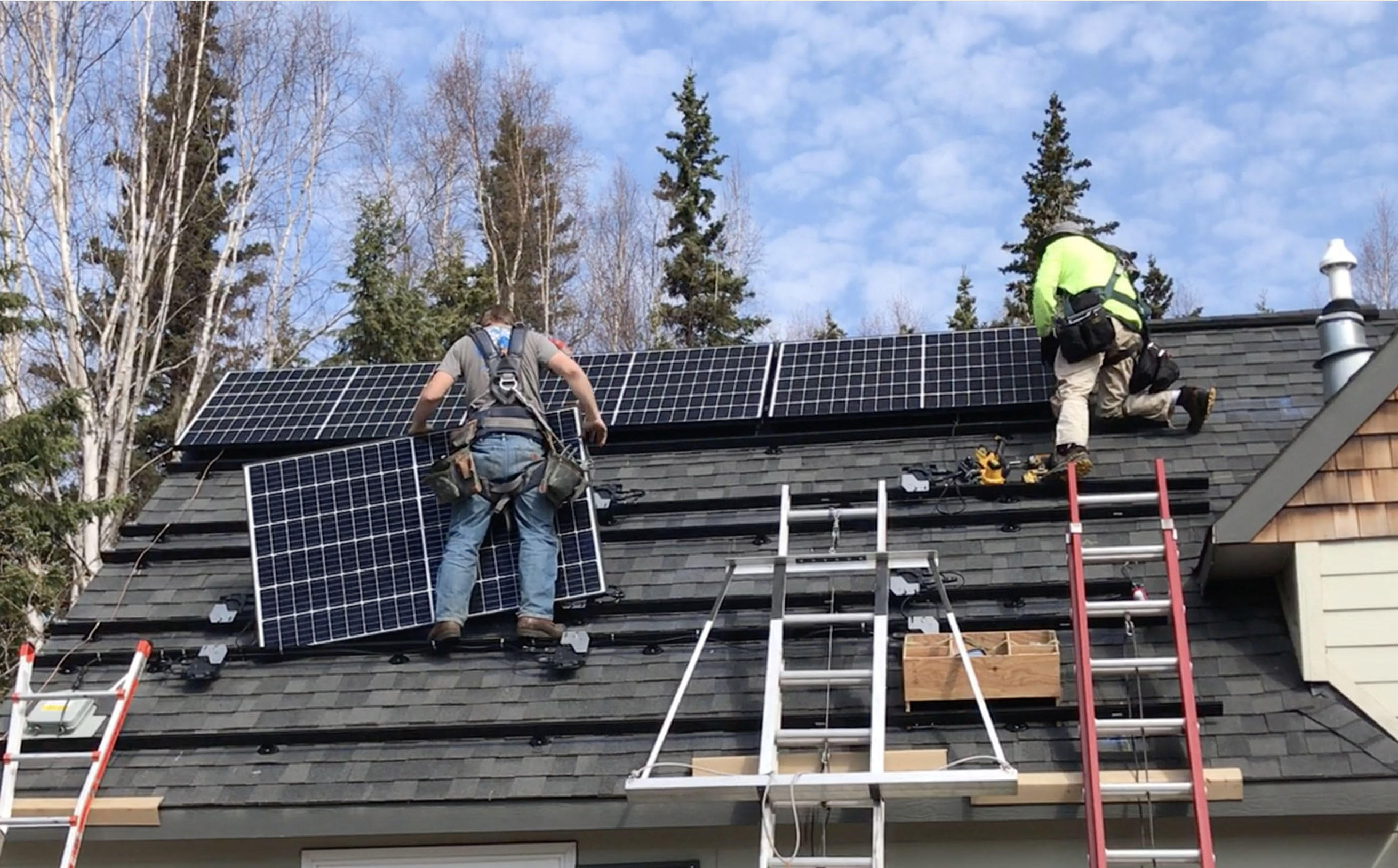 Two workers install solar panels