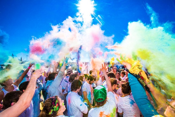 Students throw brightly colored powders at the UAF color run.