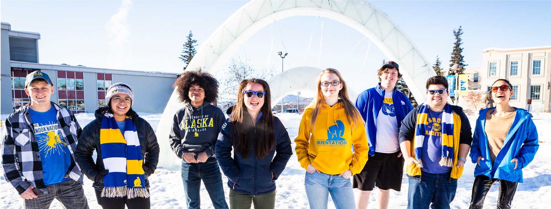 student ambassadors standing in front of ice arch in Cornerstone Plaza and smiling at the camera