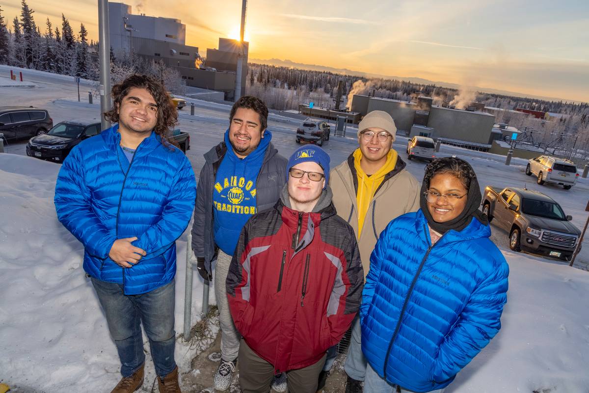 UAF student ambassadors pose outside on the Fairbanks Campus at sunset
