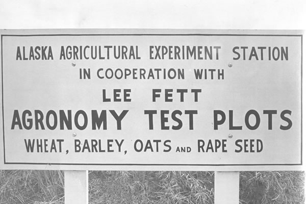 Historical Photo, sign stating "Alaska Agricultural Experiment Station"