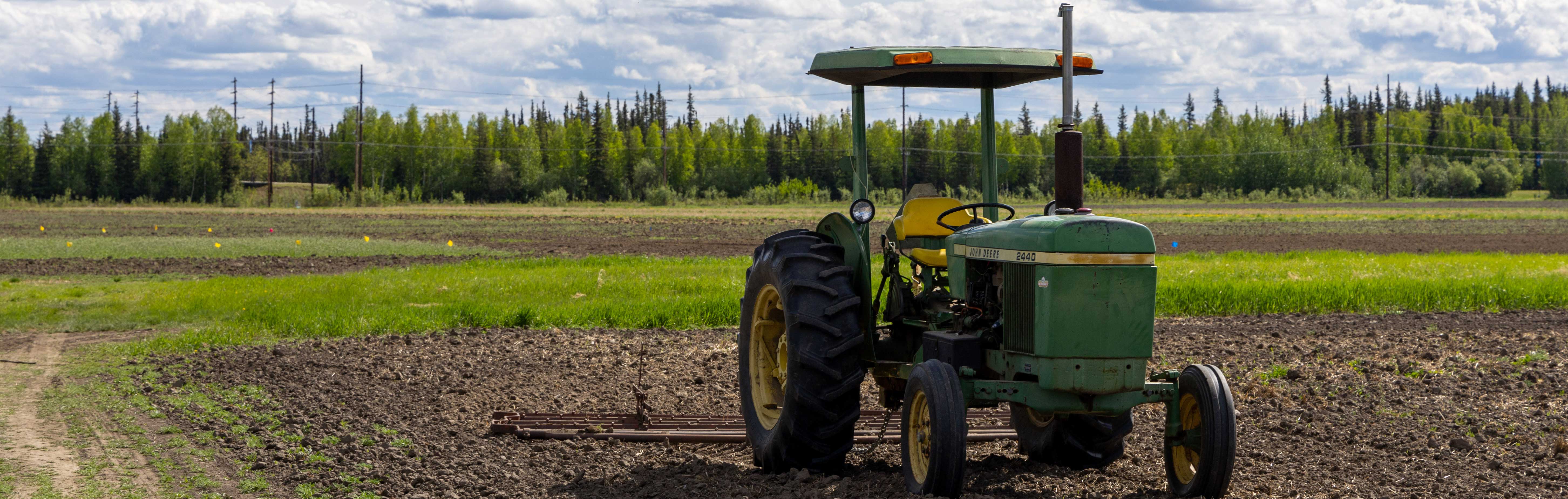 a green tractor in a field 