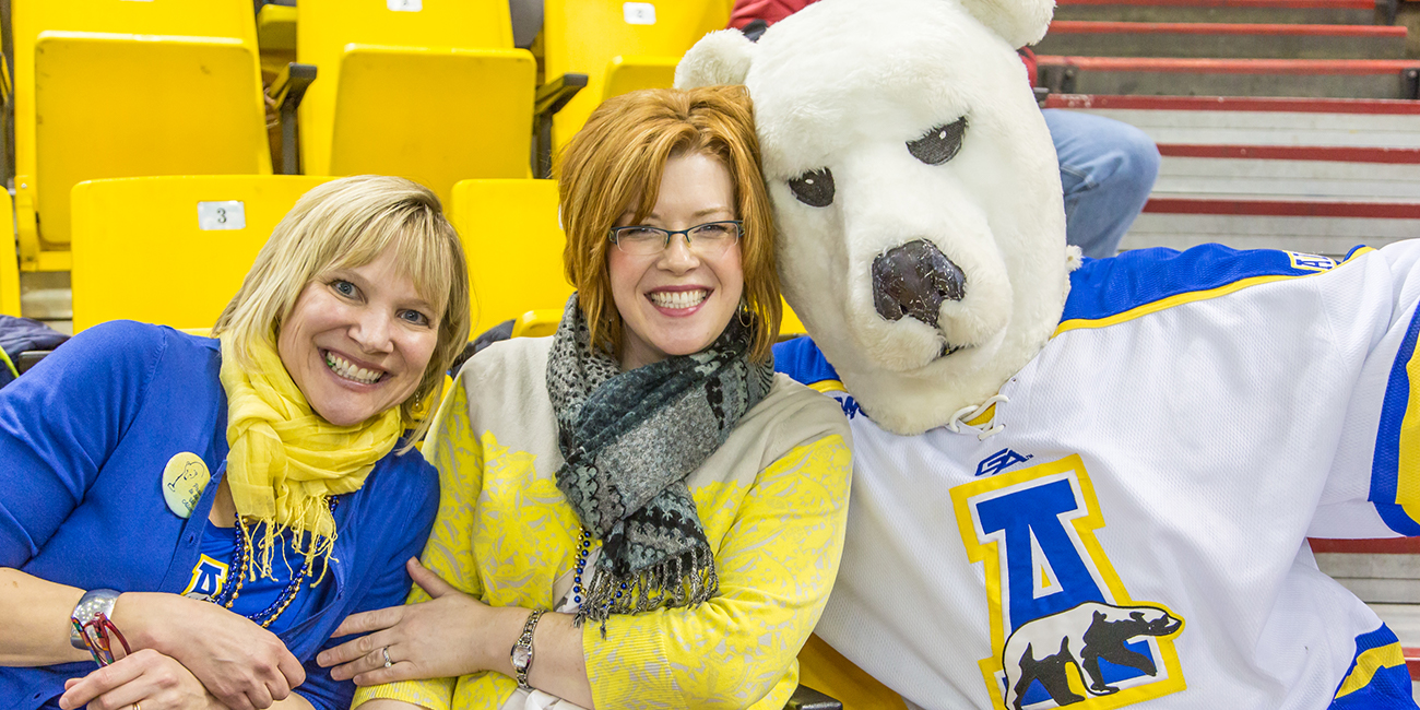 UAF Alumni director Kate Ripley and Development's Emily Drygas found a friendly face in the crowd while watching the UAF-UAA hockey battle in Anchorage's Sullivan Arena.