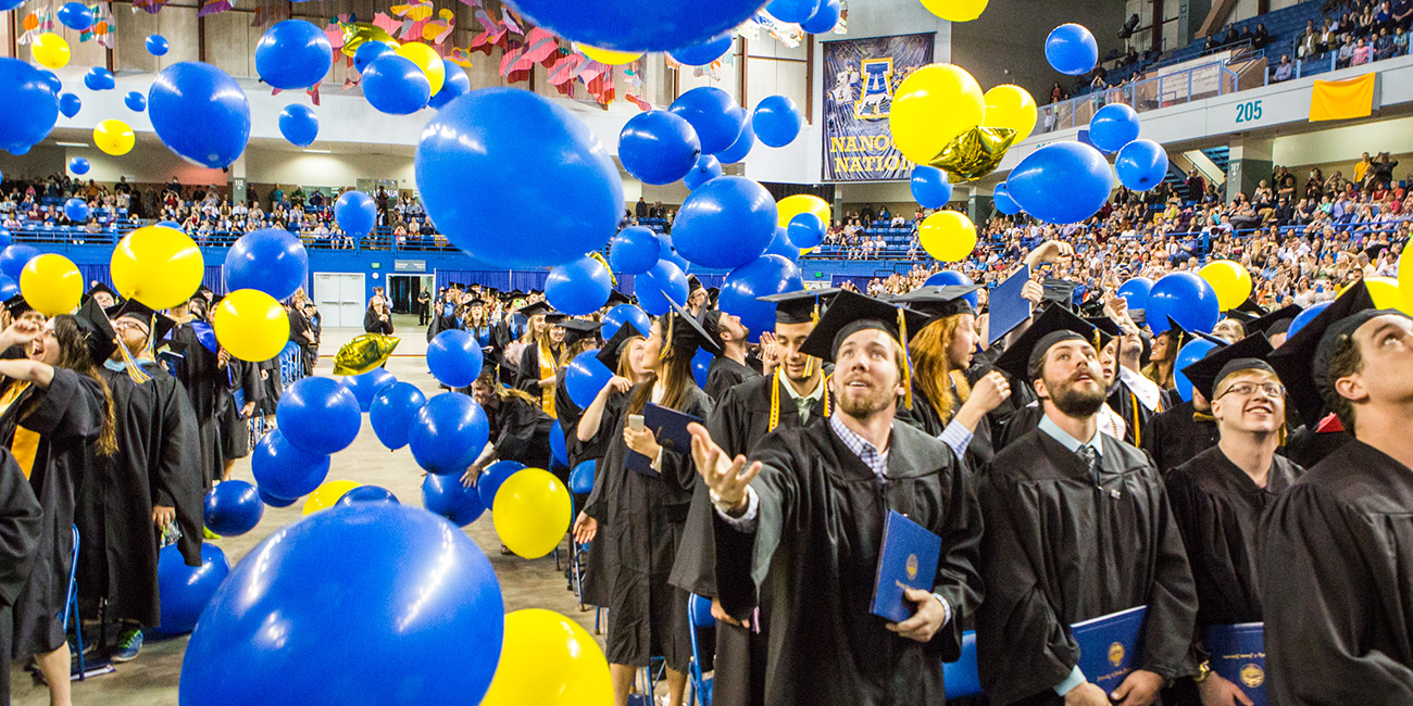 Graduates react to the ceremonial balloon drop during the Commencement 2016 ceremony.