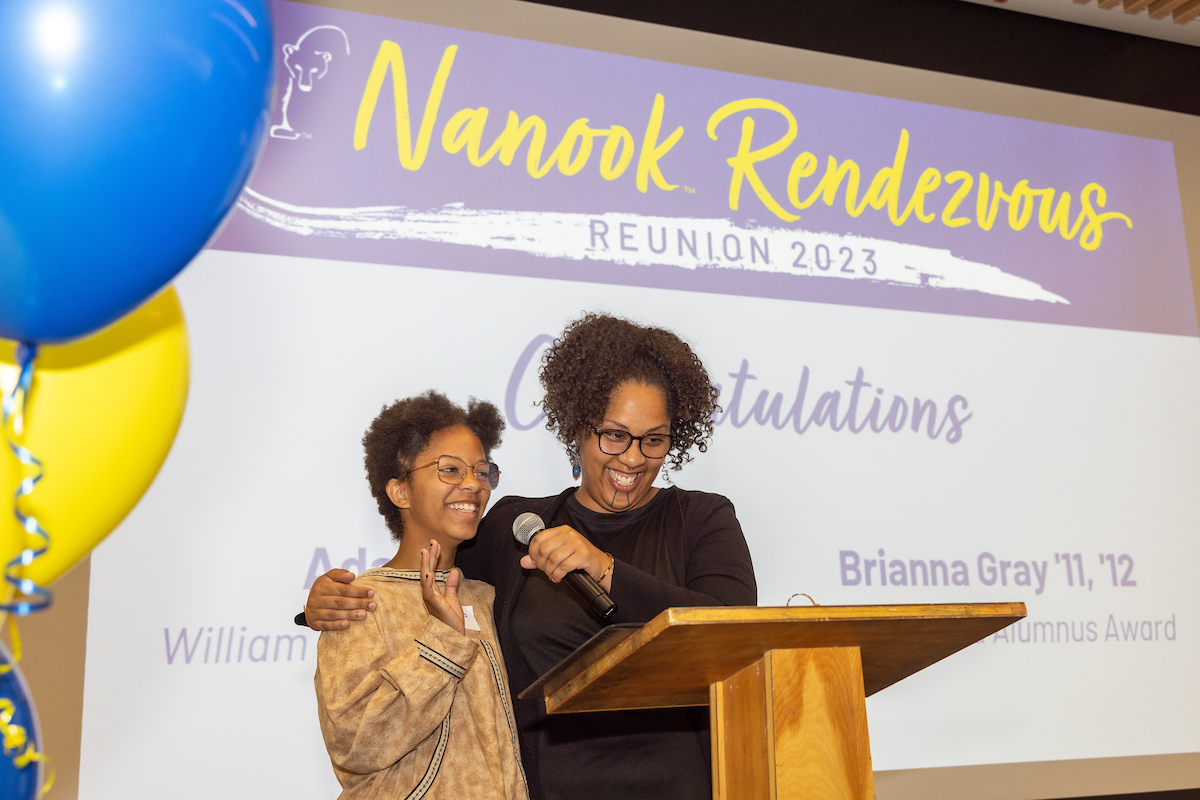 UAF Alumnus Brianna Gray ('11, '12), right introduces her daughter Aaliyah Gray while giving her acceptance speech after receiving the 2023 Distinguished Alumnus Award UAF Alumni gather in the Regents' Great Hall on the UAF campus for the Annual Nanook Rendezvous Alumni Reunion Reception and Alumni Awards Thursday, evening, July 13, 2023.